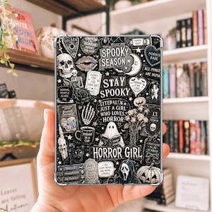 May include: A rectangular tablet case featuring a black and white collage of horror-themed illustrations, including a skull, a ghost reading a book, a black cat, pumpkins, and text that reads Spooky Season, Stay Spooky, and Horror Girl.