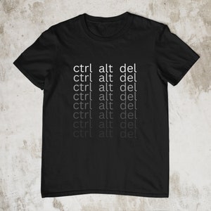 May include: Black t-shirt with the text "ctrl alt del" repeated in a fading pattern, starting with white and fading to grey.