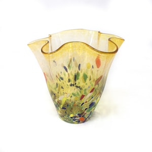 Könnte beinhalten: Eine gelbe Glasvase mit einem gewellten Rand und einem bunten Konfetti-Muster.