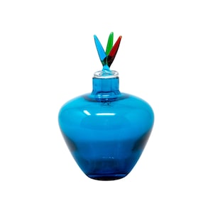 May include: A vibrant blue glass bottle with a decorative stopper. The stopper features three colorful glass elements in green, red, and blue. The bottle has a rounded body and a clear glass neck.