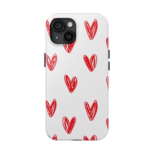 May include: White phone case with a repeating pattern of red, hand-drawn hearts. The case has a camera cutout and a smooth, glossy finish. The hearts are irregularly shaped, adding a playful touch to the design.