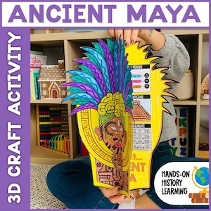 May include: A colorful 3D craft activity titled "ANCIENT MAYA" is held up. The craft features a detailed illustration of a Mayan figure with a feathered headdress. The text "3D CRAFT ACTIVITY" is on the side. The craft is for hands-on history learning.
