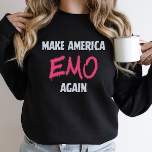 May include: Black sweatshirt with the text "MAKE AMERICA EMO AGAIN" in white and pink lettering.