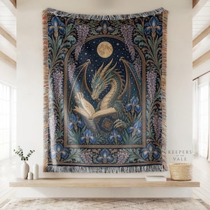 May include: A woven throw blanket featuring a dragon reading a book under a full moon, surrounded by blue irises and purple wisteria. The design is framed by an ornate archway with a dark blue starry background and fringed edges on all sides.