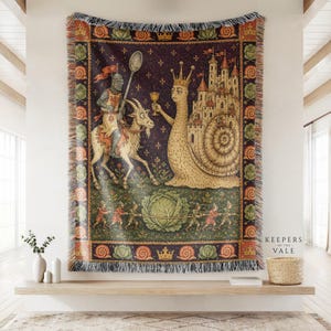 Könnte beinhalten: Eine gewebte Wandteppichdecke mit einer mittelalterlichen Illustration eines Ritters auf einer Ziege, der einen Löffel hält und einem großen, gekrönten Schneckenwesen mit einer Burg auf dem Gehäuse gegenübersteht. Unten ziehen kleine Figuren einen Kohl.