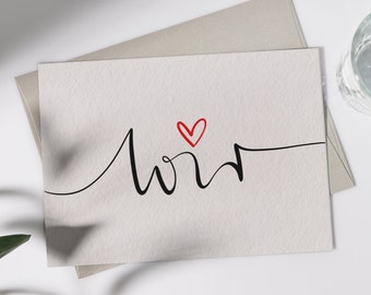 May include: A white card with the word "love" written in black cursive script. A small red heart is drawn above the word. The word "fili" is written in black cursive script at the bottom of the card.