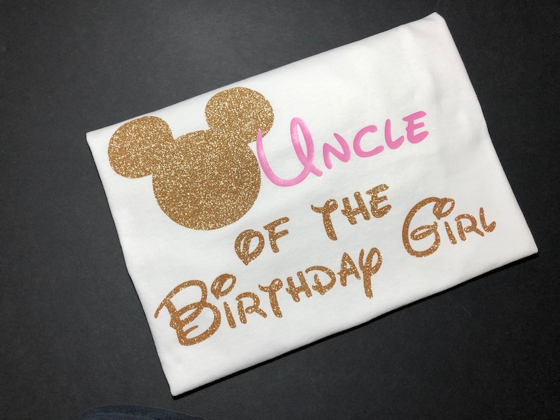 May include: White t-shirt with gold glitter Mickey Mouse ears and the text "Uncle of the Birthday Girl" in pink and gold glitter.