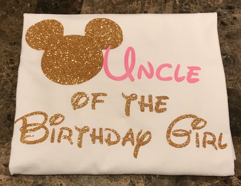 May include: White t-shirt with gold glitter Mickey Mouse ears and the text "Uncle of the Birthday Girl" in pink and gold glitter.