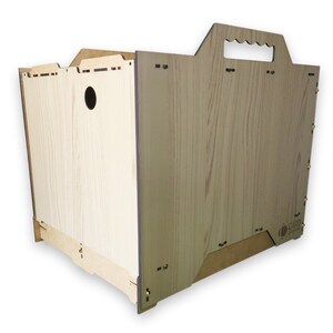 May include: A wooden crate with a handle on the top. The crate is made of light brown wood with a wood grain pattern. The crate has a small hole on the side. The crate is labeled "CARD BOARD"