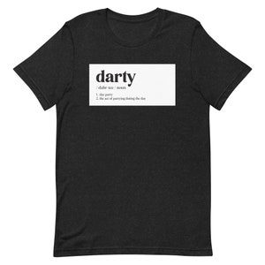 May include: A dark heather gray short-sleeve t-shirt featuring a white rectangular graphic on the chest. The graphic displays the word "darty" in a bold black font, followed by the phonetic spelling and the definition: 1. day party 2. the act of partying during the day.