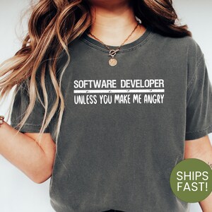 May include: A dark gray t-shirt with the text "Software Developer - Unless You Make Me Angry" printed in white.