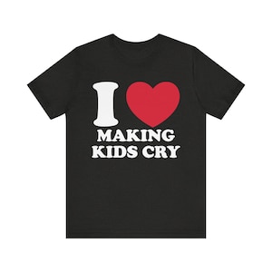 Puede incluir: Camiseta negra con un corazón blanco y el texto "I ♥ MAKING KIDS CRY" en blanco.