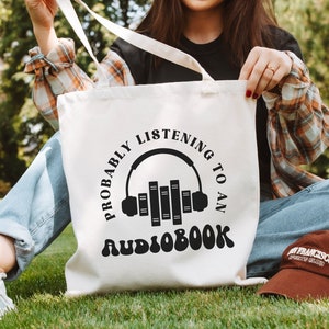 A cotton canvas tote bag that says probably listening to an audiobook.