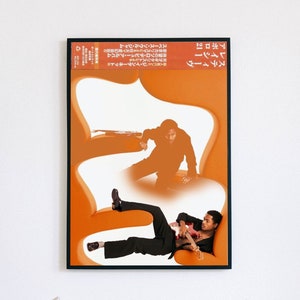May include: A poster with an orange background featuring two men. The man on the left is standing in a crouched position, while the man on the right is lying down playing a guitar. The poster has Japanese text that reads "Steve Lacy, Apollo 20".
