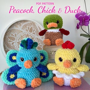 May include: Three crocheted stuffed toys: a peacock with blue and green feathers, a yellow chick with a white skirt, and a brown duck with a green head.  PDF PATTERN Peacock, Chick & Duck.