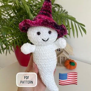 Op de afbeelding: Haakpatroon voor een witte geest met een roze en zwarte heksenhoed. Het patroon is beschikbaar als PDF-download. De afbeelding bevat ook een Amerikaanse vlag.