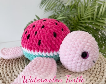 May include: A crocheted watermelon turtle amigurumi toy with pink and green accents. The toy is sitting on a woven wicker surface. Watermelon Turtle PDF Pattern.