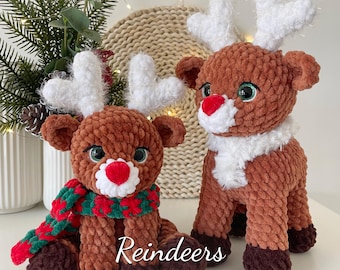 Puede incluir: Dos peluches de reno tejidos a crochet. El reno más grande está de pie y tiene un collar de piel blanca. El reno más pequeño está sentado y lleva una bufanda roja y verde. Ambos renos tienen pelo marrón, cuernos blancos y nariz roja. El texto "Reindeers PDF PATTERN BUNDLE" está en la parte inferior de la imagen.