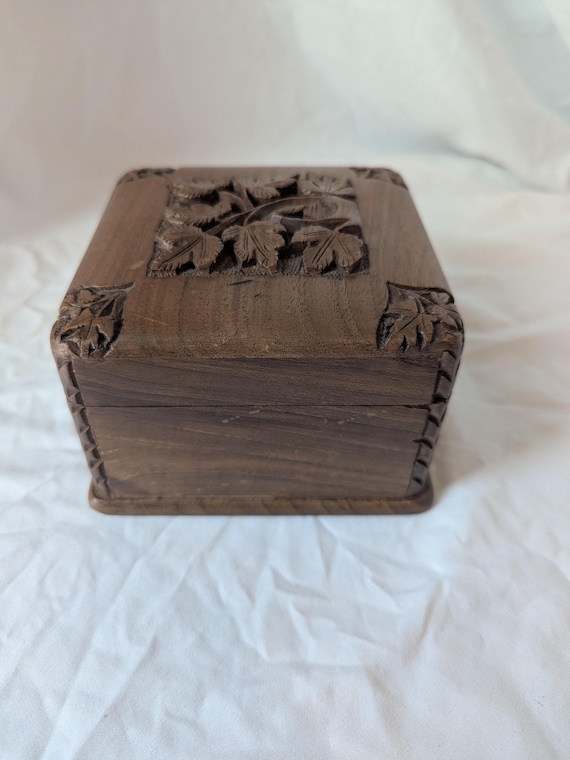 A mid-century carved wooden puzzle box with a hidden opening mechanism and velvet lining — the kind of thing that sits on a shelf and makes every visitor ask 'how do you open that?'