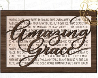 Peut inclure: Un cadre en bois brun avec un fond blanc et le texte "Amazing Grace" dans une police décorative. Le texte est entouré d'une police plus petite avec un hymne sur la grâce.