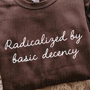 Può includere: Una felpa marrone con la scritta bianca "Radicalized by basic decency". La felpa è ripiegata su una superficie tessuta. La parte inferiore dell'immagine include il testo "SVG DXF PNG PDF FILES + DIGITAL DOWNLOAD".