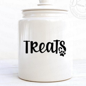 May include: White ceramic jar with a black paw print and the word "Treats" in a cursive font. The jar has a lid and is sitting on a white surface.