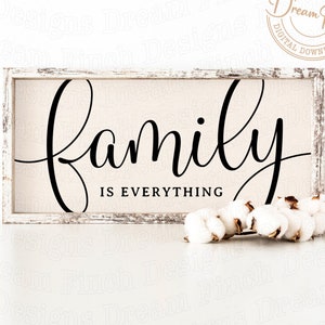 May include: A white wooden sign with a distressed finish, featuring the text "family is everything" in black cursive script.