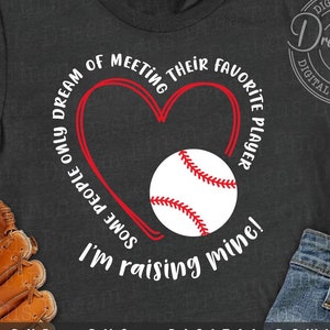 May include: A gray t-shirt with a red heart and baseball graphic. The text on the shirt reads "I'm raising some people only dream of meeting their favorite player mine!"