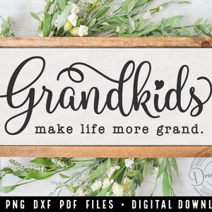 May include: A wooden sign with the text "Grandkids make life more grand." The text is in black cursive font with a small heart symbol above the "d" in "grandkids".