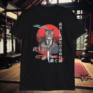 May include: Black t-shirt with a graphic of a cat holding a sword. The cat has tattoos and is wearing a suit. The background is a red sun with Japanese text that reads "武士道" and "猫が地獄に落ちる", which translates to "Bushido" and "The cat falls into hell".