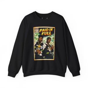 以下が含まれることがあります： コミックブック風のグラフィックが特徴の黒いスウェットシャツ。「PAID IN FULL」と書かれたグラフィックには、金の鎖と金を持っている2人の男性が描かれています。スウェットシャツは長袖で、クルーネックです。
