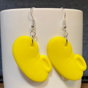 Peut inclure: Une paire de boucles d'oreilles pendantes jaunes en forme d'oreilles de Mickey avec des crochets argent&eacute;s.
