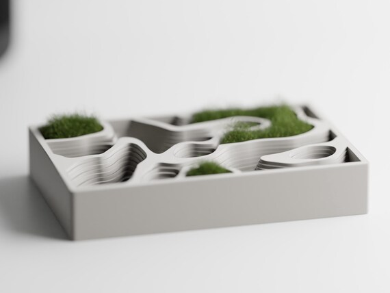 Front view of the ContourCove topographic tray styled with small patches of dry moss