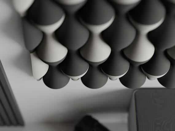 Angled close-up of charcoal and ivory HaloWeave tiles showing sculpted depth and shadow