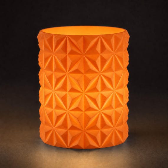 Close-up of the PrismGlow geometric LED tealight sleeve in Pumpkin Orange