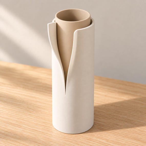 Elevated three-quarter view of Linen Sand Vellori with a Bone White collar and Desert Tan inner vessel, showing the empty circular mouth and flowing edges.