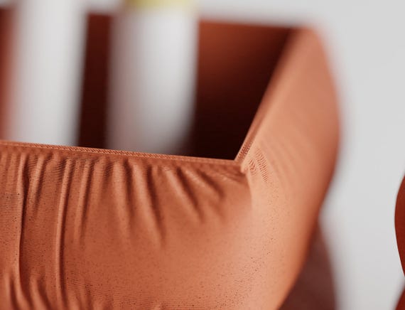 Detail close-up of the rounded CushionCove pen holder rim and gathered surface