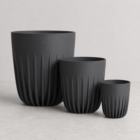 Close-up comparison of three complete CrownRill architectural rib planters in Charcoal