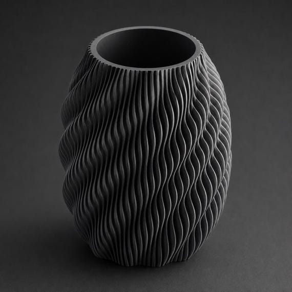 Quietflow sculptural vase in Black with dramatic lighting on the layered texture