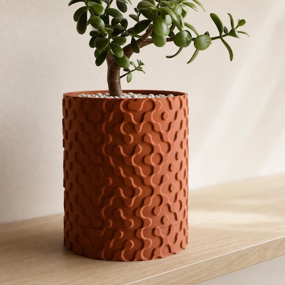 Terracotta RippleGlyph planter showing the raised droplet relief and tray seam