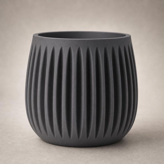 Close-up of the empty GrooveNest planter in Charcoal showing the deep pointed vertical flutes