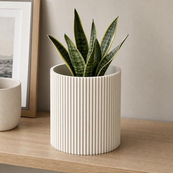 Bone White StillRib indoor planter with an upright snake plant on an office shelf