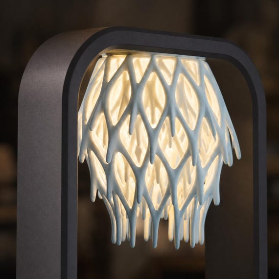 Close-up of the Charcoal frame and Ice Blue branching lattice shade with warm light