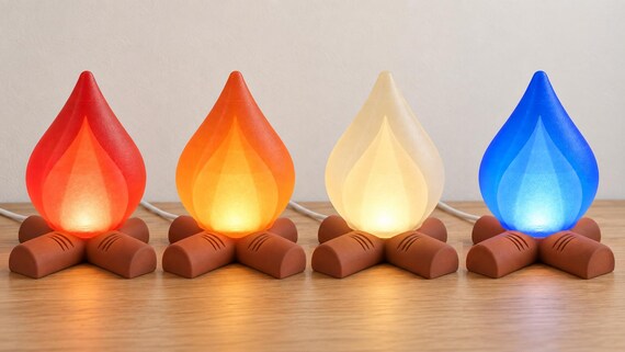 Four Emberkin lamps with Terracotta log bases and Red, Orange, Mellow Yellow and Blue translucent shades, showing the four named colorways.