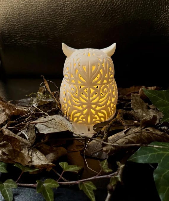 Rear view of the glowing solid owl lamp showing raised feather ornament