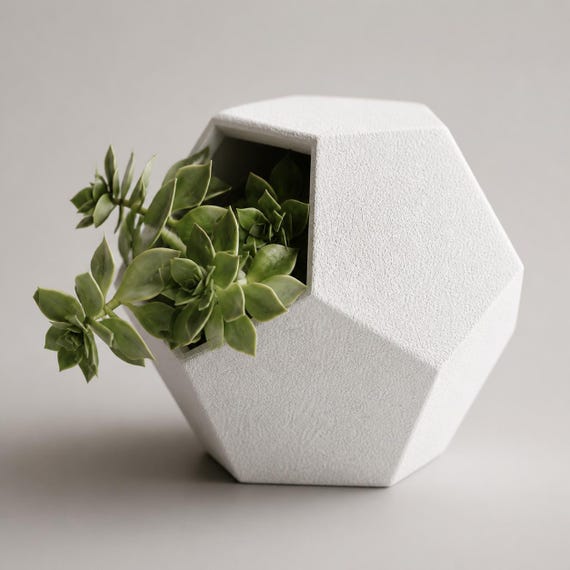 Elevated close-up of the White Tilted Bloom side-opening planter with a trailing succulent