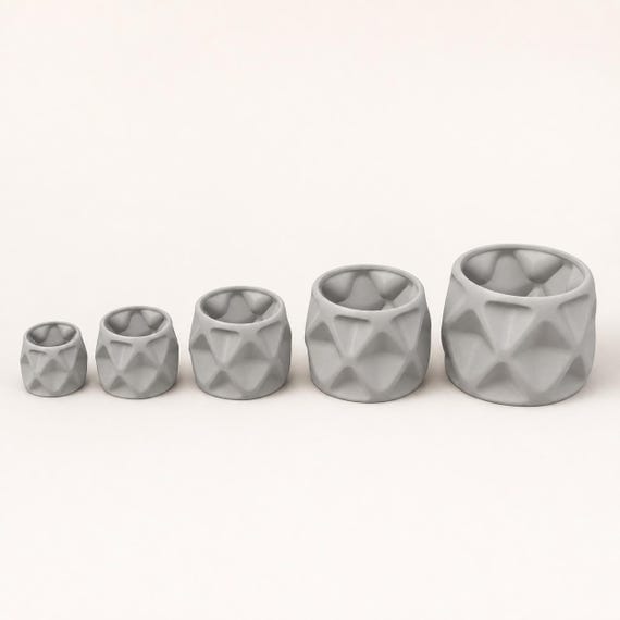Close-up comparison of all five proportional PillowFacet planter sizes in Light Grey