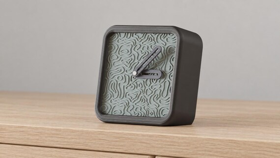 Contourhour Desk Clock dark frame and pale textured contour face in a close angled view on oak.
