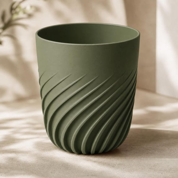 Elevated close-up of an empty medium Flowspire spiral rib planter in Dark Green