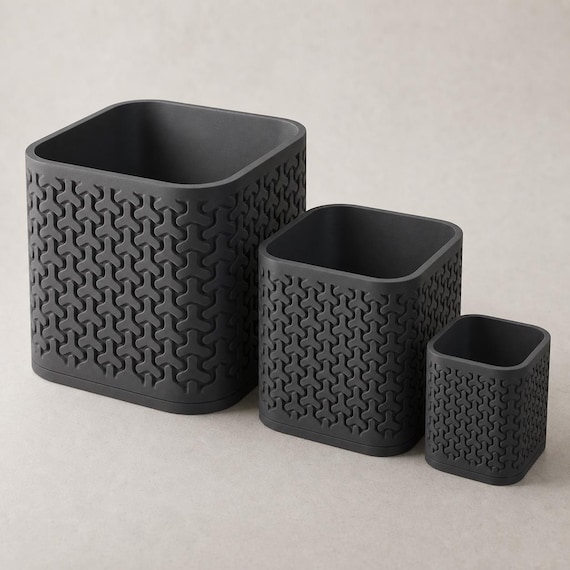 Close-up comparison of three complete TriLoom geometric planters in Charcoal
